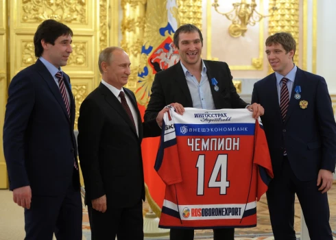 Krievijas prezidents Vladimirs Putins, otrais pa kreisi, pozē kopā ar hokejistiem Aleksandru Ovečkinu, centriski pa labi, Nikolaju Kuļominu, pa labi un Danisu Zaripovu, pa kreisi, pieņemšanā, godinot hokeja valstsvienības uzvaru pasaules čempionātā hokejā, Kremlī Maskavā 2014. gada 27. maijā..