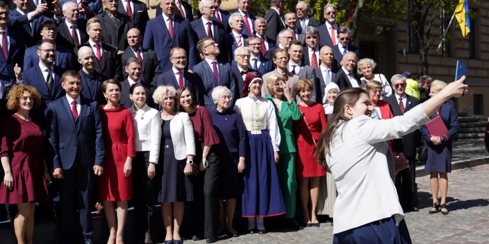 FOTO: tautastērpos un ar smaidu sejā, Saeima sanāk uz svinīgo sēdi un noliek ziedus pie Brīvības pieminekļa