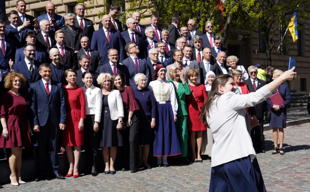 FOTO: tautastērpos un ar smaidu sejā, Saeima sanāk uz svinīgo sēdi un noliek ziedus pie Brīvības pieminekļa