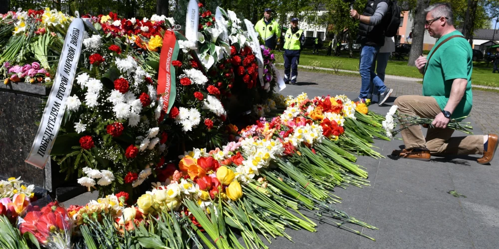 ФОТО: даугавпилчане принесли цветы к мемориалу в парке Дубровина; мужчина пришел в куртке с надписью "Россия"