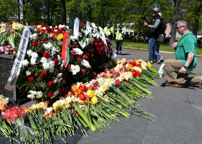 ФОТО: даугавпилчане принесли цветы к мемориалу в парке Дубровина; мужчина пришел в куртке с надписью "Россия"