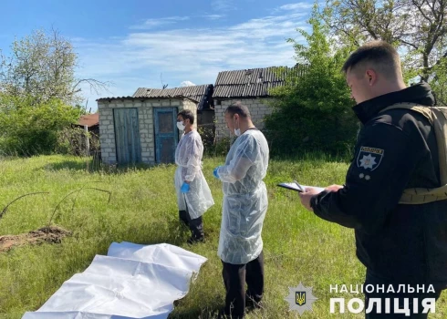 Ukrainas policists un tiesu medicīnas eksperti pie atklātajiem masu kapiem.