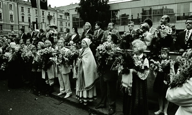 Dziesmu svētki 1990. gadā. Virsdiriģenti, valdības pārstāvji un viesi pie Dailes teātra. 1. rindā no labās: A.Derkēvica, J.Dūmiņš, Lilija Zobens, I.Kokars, Roberts Zuika, Terēze Broka, J.Erenštreits, J.Zirnis; 2. rindā no labās: Andrejs Krastiņš, I.Godmanis, Gražina Ručīte, Raimonds Pauls, Vītauts Landsberģis, A.Gorbunovs, Arnolds Rītels, Ingrīda Rītela, Arnis Kalniņš, I.Bišers.