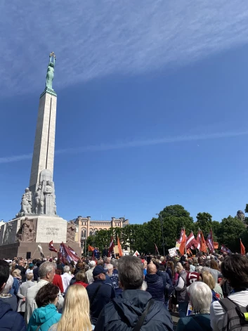 Жители Риги с плакатами и латвийским флагами у памятника Свободы  (Фото: очевидец)