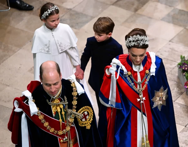 Princese Šarlote ar brāli princi Luisu pie rokas Vestminsteras abatijā, ierodoties uz karaļa Čārlza III kronēšanas ceremoniju.