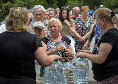 Vietējie iedzīvotāji ņem dzeramo ūdeni, pēc tam, kad tika pārrauts Nova Kahovkas aizsprosts.
