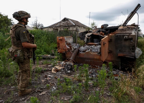  Военнослужащий Украины стоит рядом с уничтоженной российской боевой машиной пехоты БМП-3 в недавно освобожденном село Благодатне, недалеко от линии фронта в Донецкой области, 17 июня 2023 года.