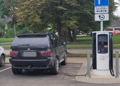 "Пистолет" зарядки вставлен в проем под крылом заднего колеса BMW. (Фото: Twitter.com / Roberts Rambāns)