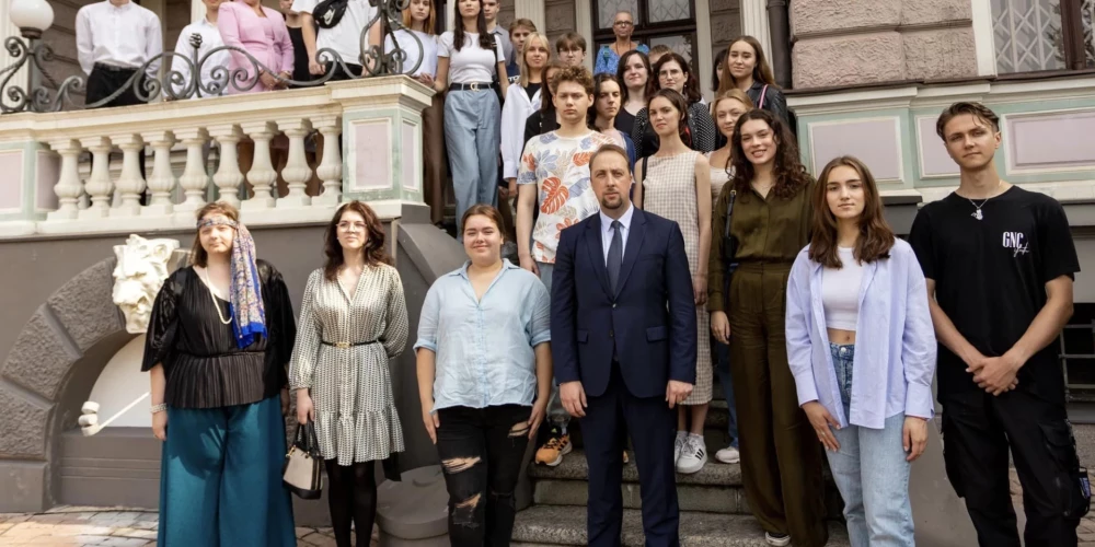 Krievijas vēstniecības darbinieks ar stipendiātiem no Latvijas.