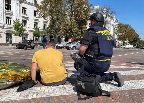 Ukrainas amatpersona un civiliedzīvotājs blakus okupantu raķešu uzbrukuma upurim Čerņihivā. 2023. gada 19. augusts