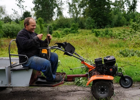 Vīrietis asina motorzāģa ķēdi, lai likvidētu vētras radītos postījumus Dobeles novada Lejasstrazdos.