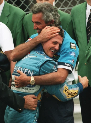 Šajā 1994. gada 15. maija foto “Benetton” komandas menedžeris Flavio Briatore pēc uzvaras Pirmās formulas Monako “Grand Prix” izcīņā apskauj vācu braucēju Mihaēlu Šūmaheru.