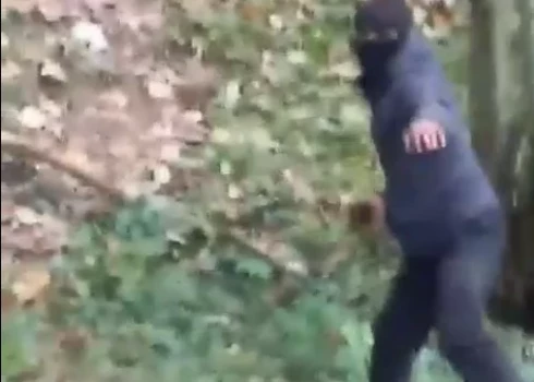 Iespējamais robežkpārkāpējs met akmeni.