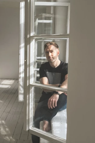 "Deviņdesmitajos pēc koncerta ballīte tikai sākās, bet tagad – visi mūziķi pa mājām, galds paliek saklāts, alkohola pudeles neatvērtas. Rīt jāstrādā, jo citādi nevarēsi samaksāt, kad Sadales tīkls atkal pacels tarifus," par šodienas realitāti saka Jānis Stībelis. Foto: Diāna Petešenkova