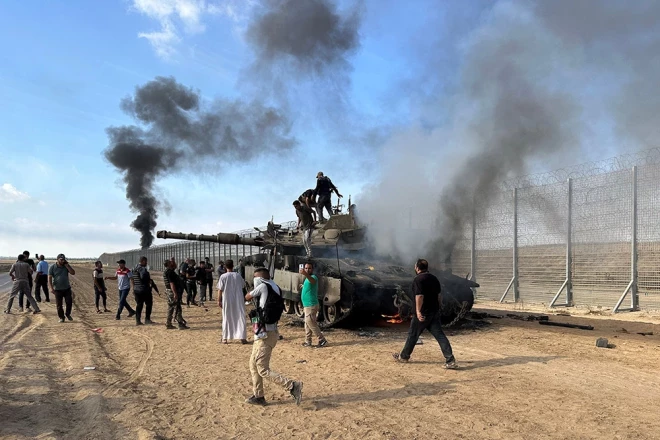 Palestīnieši priecājas par degošu Izraēlas tanku, kam uzbruka "Hamas" kaujinieki, kuri iefiltrējās Izraēlas un Gazas robežas Izraēlas pusē. 