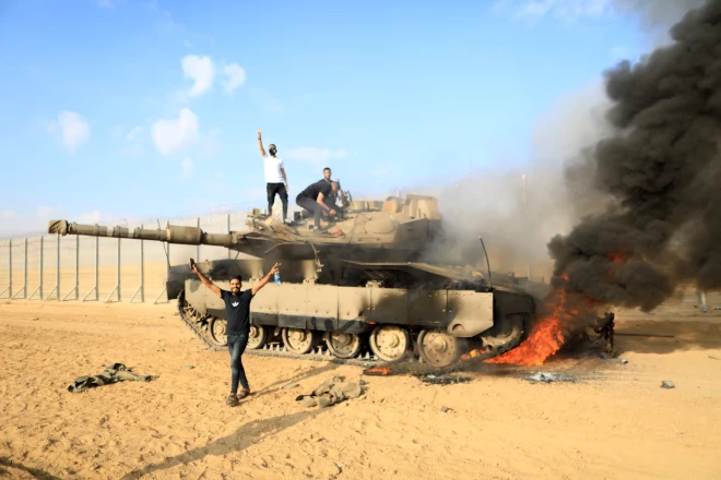 Palestīnieši priecājas uz degoša Izraēlas armijas tanka.