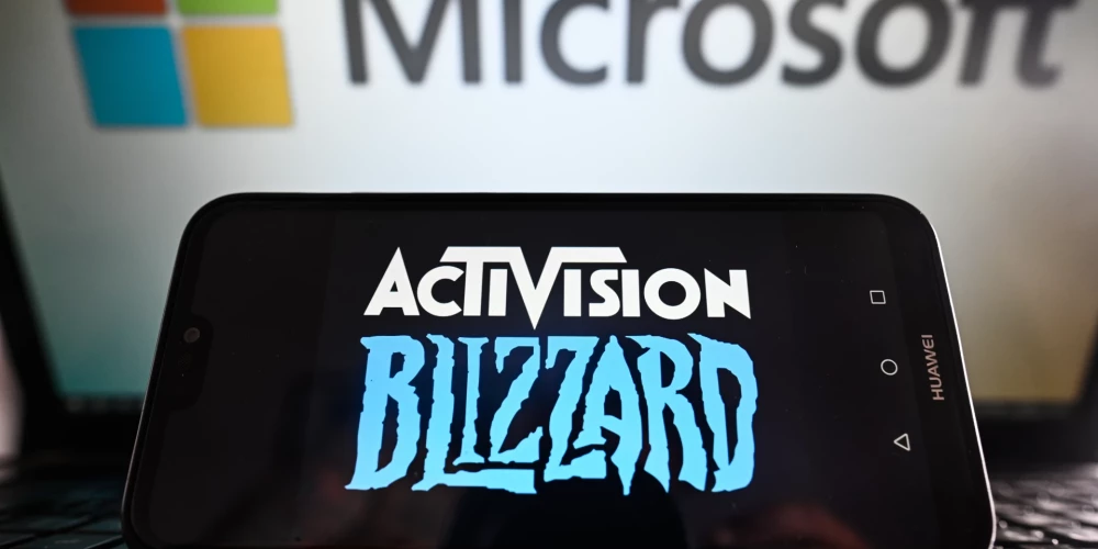 "Activision Blizzard" logotips viedtālrunī uz "Microsoft" logotipa fona