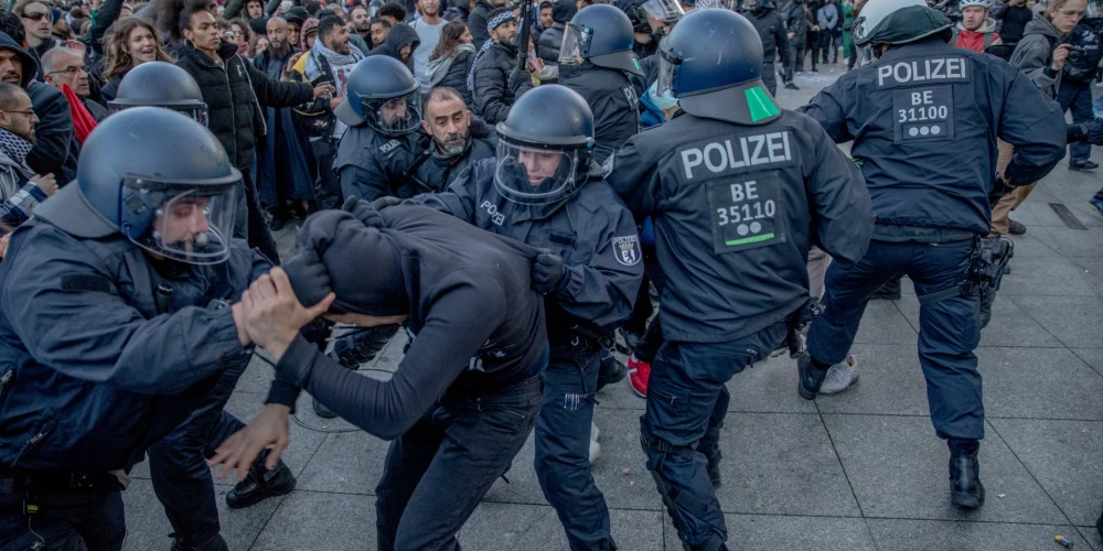 Berlīne, Vācija: Policija mēģina izklīdināt pūli, aicinot dalībniekus pamest Potsdamas laukumu.