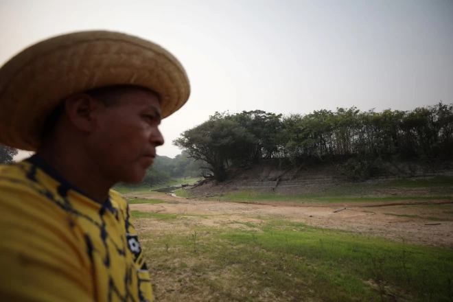 Amazones džungļu iedzīvotājs pie izsūkušas upes.