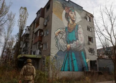 Ukraiņu aizstāvis pastaigājas blakus dzīvojamai ēkai, kas smagi bojāta pastāvīgos Krievijas militārajos uzlidojumos frontes līnijas pilsētiņā Avdīvkā Doneckas reģionā, 2023. gada 8. novembrī.