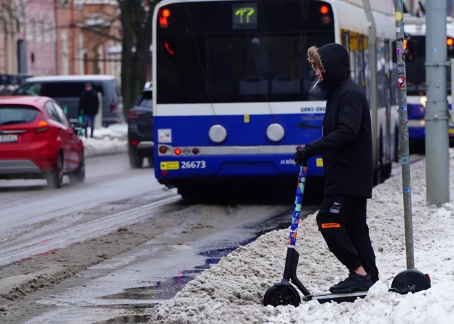 Jaunietis uz elektriskā skrejriteņa Merķeļa ielā.