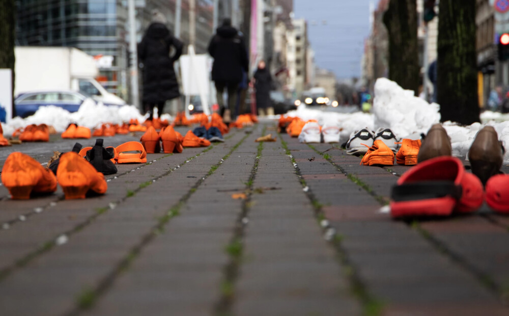 FOTO: pie valdības ēkas izlikti oranži kurpju pāri, simbolizējot nogalinātās un no vardarbības cietušās sievietes