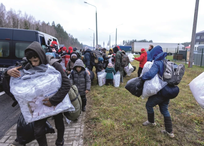 Migranti pulcējas loģistikas centrā Baltkrievijas robežas pusē pie Grodņas. 2021. gada novembris.