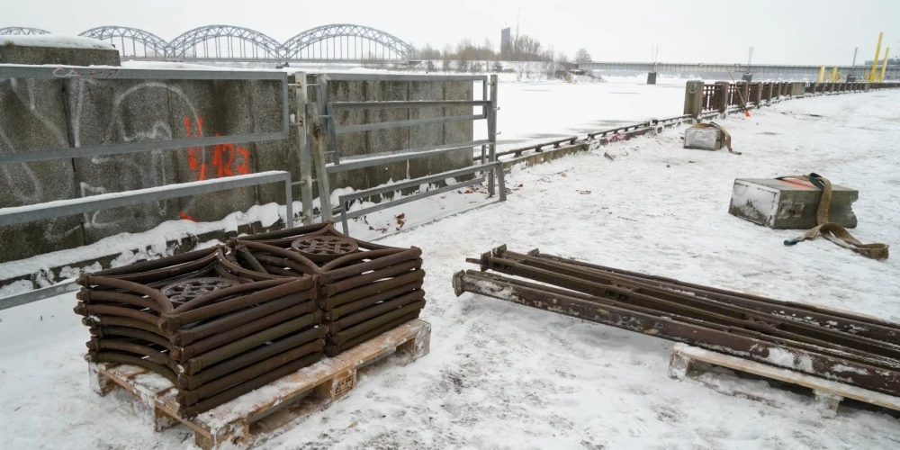 Набережная огорожена решеткой с элементами, изображающими символы советской эпохи, которой примерно 60 лет.