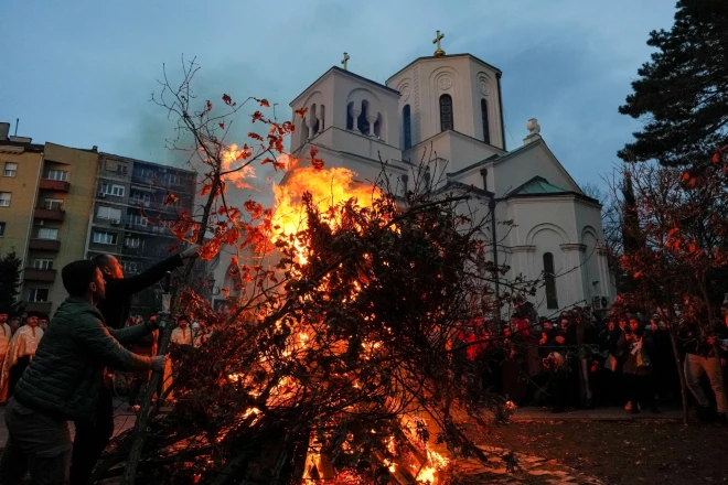 Cilvēki sadedzina kaltētus ozola zarus - pareizticīgo Ziemassvētku vakara simbolu Jūla baļķi - pie Svētā Sava baznīcas Belgradā.