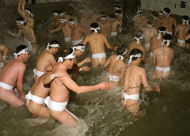 Men make their way through a cleansing pool of water at Hadaka Matsuri or the Naked Man Festival, Sadaiji Temple, Okayama, Japan