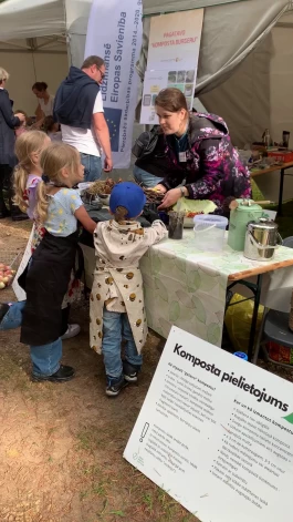 Par kompostēšanu var stāstīt visur, un atsaucīgi klausītāji ir arī bērni. Zane Kopštāle dalās savās zināšanās Miķeļdienā Brīvdabas muzejā, “Interreg” sadarbības dienā.