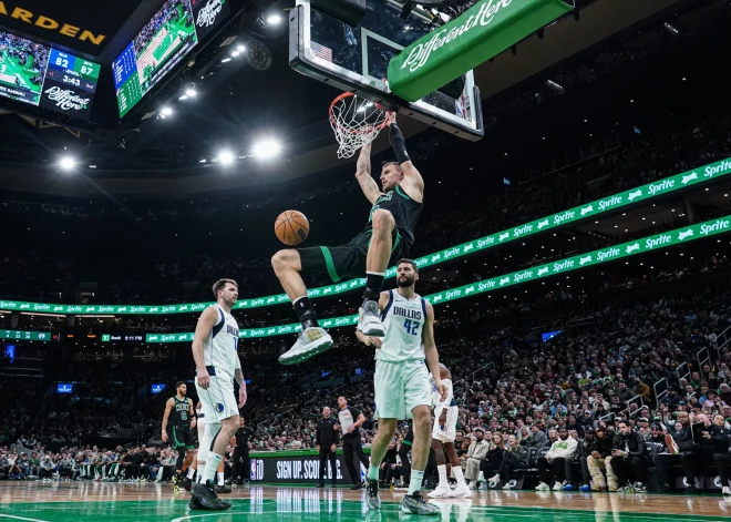 Maksi Klebers (#42) un Luka Dončičs (#77) noskatās, kā Kristaps Porziņģis triec bumbu grozā.