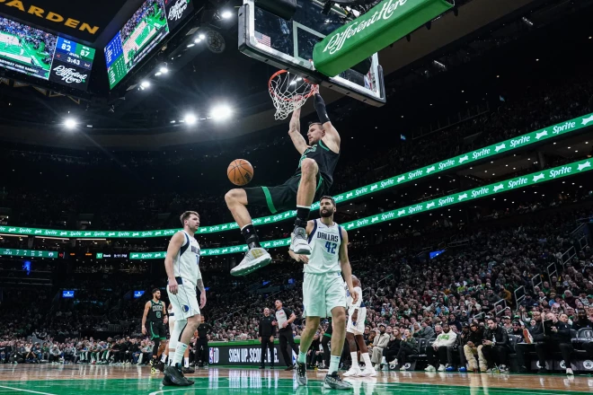 Maksi Klebers (#42) un Luka Dončičs (#77) noskatās, kā Kristaps Porziņģis triec bumbu grozā.