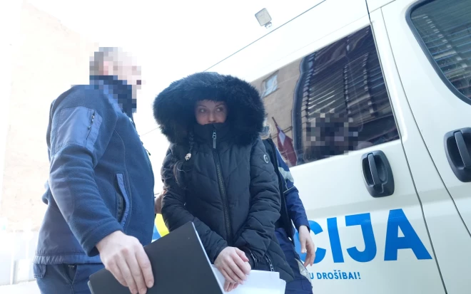 Okupācijas muzeja dedzināšanas lietā aizturētā sieviete tiek konvojēta uz tiesas sēdi Rīgas pilsētas Vidzemes priekšpilsētas tiesā, kur lems par apcietinājuma piemērošanu.