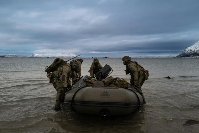 Nīderlandes jūras kājnieks novēro Sandstrandas, Norvēģijas pludmali, kad desanta kuģis tuvojas krastam vingrinājuma "Nordic Response" 24 ietvaros.