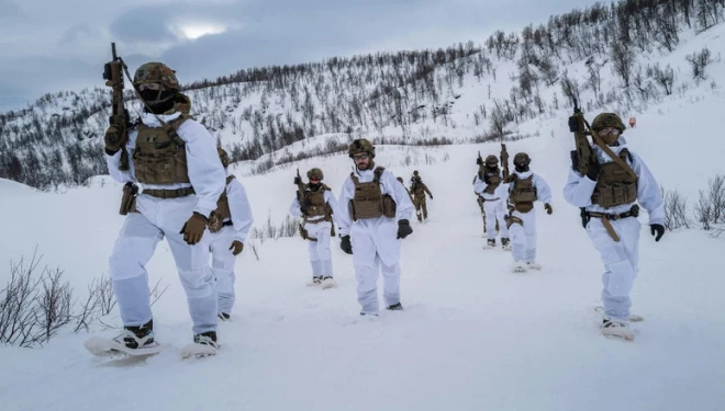 Nīderlandes jūras kājnieks novēro Sandstrandas, Norvēģijas pludmali, kad desanta kuģis tuvojas krastam vingrinājuma "Nordic Response" 24 ietvaros.