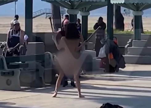Jauniete "Ievas kostīmā" cīkstās ar vāli vicinošu dāmu; pludmales apmeklētājiem mutes vaļā
