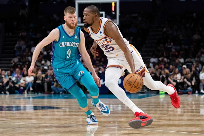 Dāvis Bertāns (#9) aizsardzībā mēģina nosegt Kevina Duranta (#35) caurgājienu.