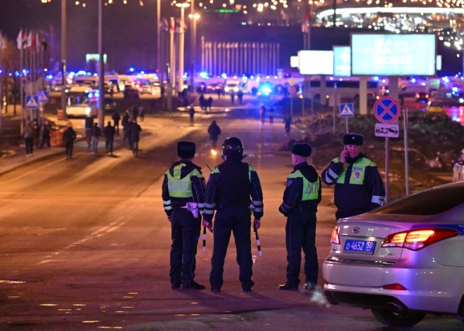 Krievijas policisti bloķē ceļu pēc uzbrukuma "Crocus City Hall" (foto: Scanpix / AP)