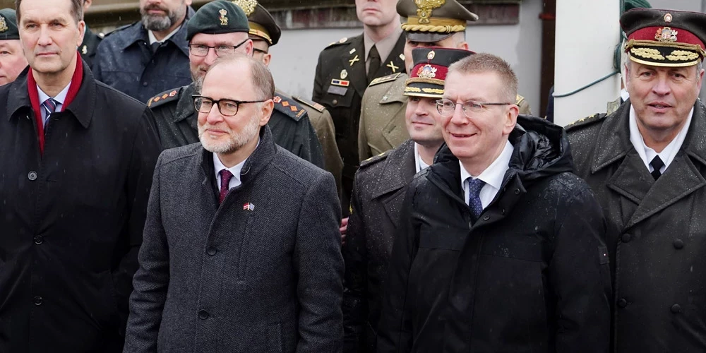 FOTO: Spītējot lietum, Rīgas pils Svētā gara tornī pacelts NATO karogs