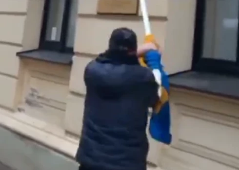 VIDEO: maskā un ar rāciju - Rīgā gaišā dienas laikā nolauž no ēkas Ukrainas karogu