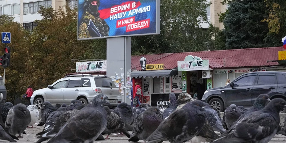 Baloži okupētajā Luhanskā sasēduši līdzās plakātam ar karavīru un Krievijas karogu. Uzraksts uz plakāta vēsta - "Ticam mūsu armijai un mūsu uzvarai!"