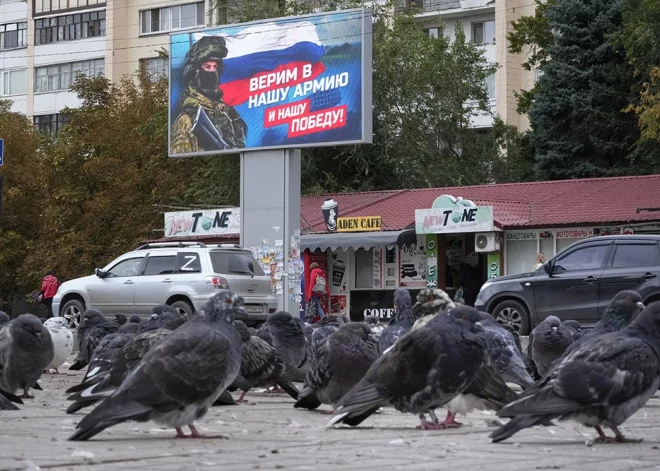 Baloži okupētajā Luhanskā sasēduši līdzās plakātam ar karavīru un Krievijas karogu. Uzraksts uz plakāta vēsta - "Ticam mūsu armijai un mūsu uzvarai!"