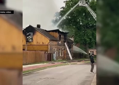 VIDEO: Ventspilī liesmas nopostījušas senu koka ēku; ugunsgrēkā cietusi sieviete