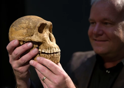 Profesors Lī Bergers ar Homo naledi galvaskausu. Tas vairāk atgādina pērtiķi, taču šai sugai bijušas cilvēciskas uzvedības iezīmes. 