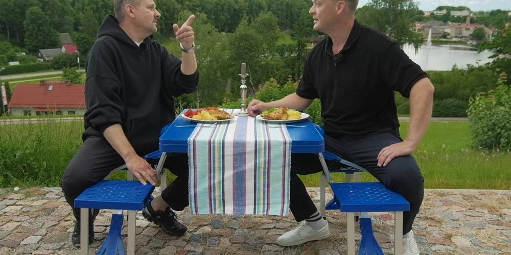 Rihards un Raimonds pasūta vairākas porcijas un dodas uzēst pie "Vietējā gurmana" galdiņa Sauleskalna virsotnē.