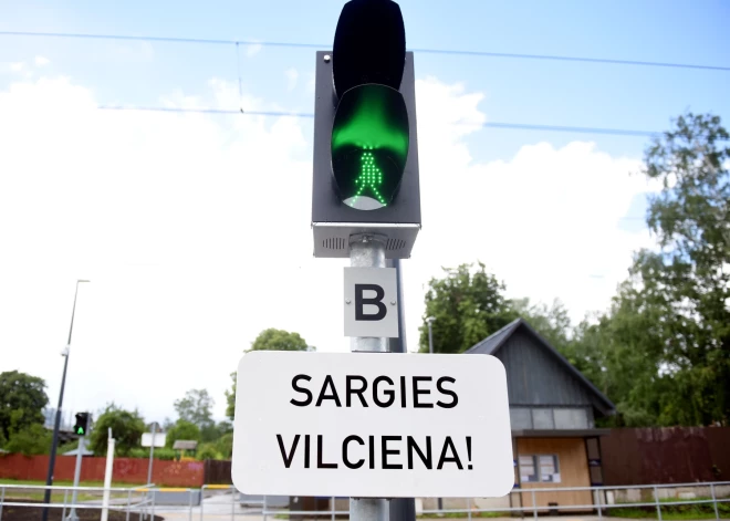 Brīdinājuma zīme "Sargies vilciena!" pie dzelceļa sliedēm.