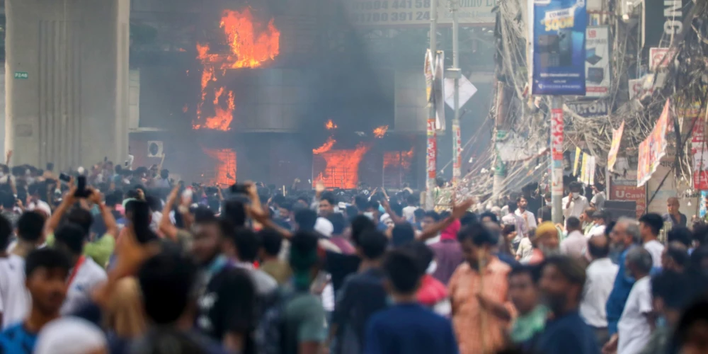 Studenti plosās Bangladešas galvaspilsētā Dakā, aizdedzinot valsts televīzijas ēku (foto: Scanpix / EPA)