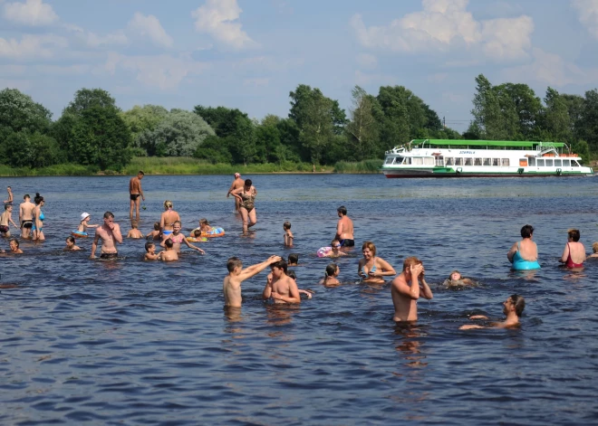 Cilvēki peldas peldvietā Lucavsalā.