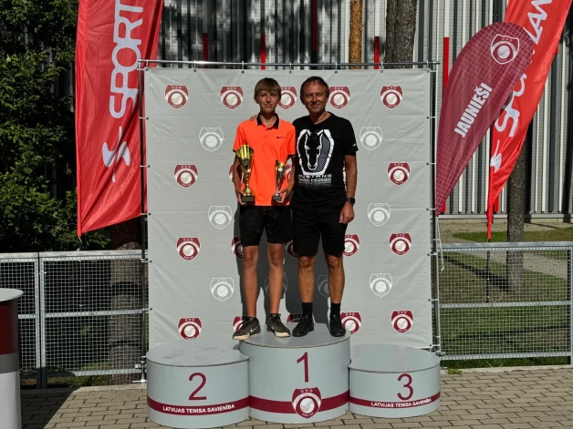 Uz uzvarētāja pjedestāla ar dēlu Ēriku. Lepns un priecīgs par dēla izcīnīto divkāršo Latvijas čempiona titulu.